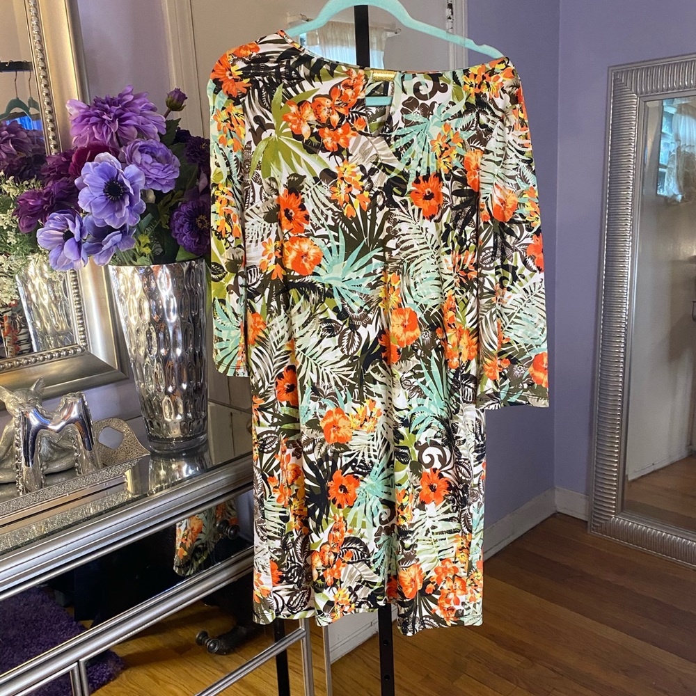 Flared sleeved floral dress with gold accent piece at the neck